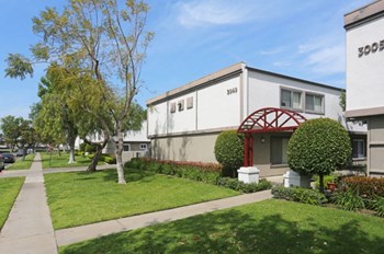 Exterior view with sidewalk by building l The Knolls Apartment in Orange CA
